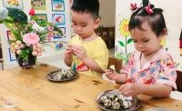 Bé tập bóc trứng cút